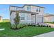 Two-story house with gray siding, brick driveway, and landscaping at 2462 Leeds St, Haines City, FL 33844