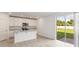 Modern kitchen with white cabinets, island, and backyard view at 2339 White Tail St, Davenport, FL 33837