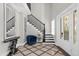 Elegant entryway with grand staircase, tile floors, and a stylish console table at 7481 Gathering Loop, Reunion, FL 34747