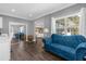 Bright sitting room with a blue velvet sofa and views into the bedroom and backyard at 7481 Gathering Loop, Reunion, FL 34747