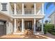Front porch with columns, rocking chairs, and double door entry at 7481 Gathering Loop, Reunion, FL 34747