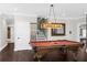 Basement game room featuring a pool table, rich hardwood floors, and an elegant light fixture at 7481 Gathering Loop, Reunion, FL 34747