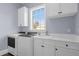 Bright laundry room with white cabinets and modern washer and dryer at 7481 Gathering Loop, Reunion, FL 34747