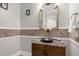 Elegant powder room with granite vanity and decorative mirror at 7481 Gathering Loop, Reunion, FL 34747