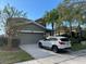 Two-story home with attached garage, landscaped yard, and palm trees at 2432 Balforn Tower Way, Winter Garden, FL 34787