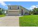 Tan two-story house with double garage and lawn at 2713 Chatham Cir, Kissimmee, FL 34746