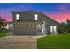 Two-story house with beige exterior and double garage at 2713 Chatham Cir, Kissimmee, FL 34746