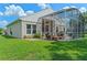 Home's back with patio, screened enclosure, and lawn at 2713 Chatham Cir, Kissimmee, FL 34746