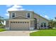 Two-story house with a beige exterior, double garage, and manicured lawn at 2713 Chatham Cir, Kissimmee, FL 34746