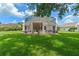 Home with a screened patio, grassy backyard, and partial view of neighboring house at 2713 Chatham Cir, Kissimmee, FL 34746