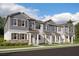 Exterior view of three-story townhomes with gray siding and brown accents at 15871 Tollington Aly, Winter Garden, FL 34787