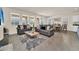 Open concept living area showcasing gray sofas and a dining area at 7876 Oak Reflection Loop, Davenport, FL 33837
