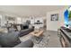 Living room with gray sofas, coffee table, and a view into the kitchen at 7876 Oak Reflection Loop, Davenport, FL 33837