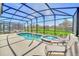 Relaxing screened pool and spa with lounge chairs at 7876 Oak Reflection Loop, Davenport, FL 33837