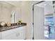 Modern bathroom with granite countertop, white cabinets, and access to a patio at 7876 Oak Reflection Loop, Davenport, FL 33837