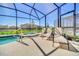Screened in pool and spa with lounge chairs at 7876 Oak Reflection Loop, Davenport, FL 33837
