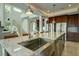 Modern kitchen with large island, stainless steel sink and breakfast bar at 1561 Corolla Ct, Reunion, FL 34747