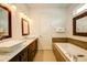 Modern bathroom with double vanity and soaking tub at 1561 Corolla Ct, Reunion, FL 34747