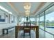 Modern dining room with stunning views and a long wooden table at 1561 Corolla Ct, Reunion, FL 34747