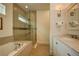 Spa-like bathroom with a soaking tub, walk-in shower, and modern vanity at 1561 Corolla Ct, Reunion, FL 34747