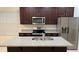 Modern kitchen with dark cabinets, granite countertops, and stainless steel appliances at 14663 Englert Aly, Orlando, FL 32827
