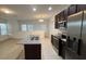 Modern kitchen with island, dark cabinets, granite counters, and stainless steel appliances at 14663 Englert Aly, Orlando, FL 32827