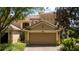 Tan two-story townhome with a two-car garage at 6316 Miramonte Dr # 106, Orlando, FL 32835