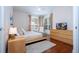 Bright bedroom featuring a king-size bed, hardwood floors, and large windows at 6316 Miramonte Dr # 106, Orlando, FL 32835
