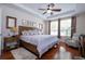 Main bedroom with wood floors, large bed, and ceiling fan at 6316 Miramonte Dr # 106, Orlando, FL 32835