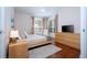 Bright bedroom featuring a king-size bed, hardwood floors, and large windows at 6316 Miramonte Dr # 106, Orlando, FL 32835