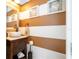 Stylish powder room with a vessel sink, and brown and white striped walls at 6316 Miramonte Dr # 106, Orlando, FL 32835