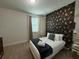 Cozy bedroom with a queen-size bed and floral wallpaper at 420 Lasso Dr, Kissimmee, FL 34747