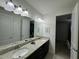 Double vanity bathroom with granite countertops and a view into bedroom at 420 Lasso Dr, Kissimmee, FL 34747