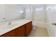Clean bathroom with wood cabinets, a bathtub, and a double sink at 8039 Northlake Pkwy, Orlando, FL 32827