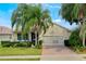 One-story house with palm trees, brick driveway, and lush landscaping at 2366 Prairie Dunes, Clermont, FL 34711
