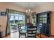 Bright dining room features glass-top table, four chairs, and built-in hutch with view to patio at 2366 Prairie Dunes, Clermont, FL 34711