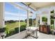 Enclosed patio with scenic golf course view, small table and chairs, and decorative accents at 2366 Prairie Dunes, Clermont, FL 34711