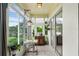Bright enclosed patio with a table and chairs, decorative cabinet, and access to the outdoors at 2366 Prairie Dunes, Clermont, FL 34711