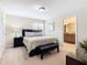 Bedroom with queen bed, bench, and en-suite bathroom at 8967 California Palm Rd, Kissimmee, FL 34747