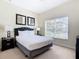 Bright bedroom with a queen-size bed and large window at 8967 California Palm Rd, Kissimmee, FL 34747