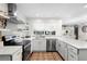 Modern kitchen with white cabinets, quartz countertops, and stainless steel appliances at 115 Marcy Blvd, Longwood, FL 32750