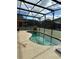 Screened-in kidney shaped swimming pool in backyard at 154 Barefoot Beach Way, Kissimmee, FL 34746