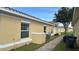 Brick paver walkway between tan buildings with landscaping at 1646 Cumin Dr, Poinciana, FL 34759
