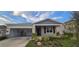 Single-story home with gray siding, landscaping, and a two-car garage at 1007 Theodore St, Davenport, FL 33837
