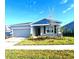 Single-story home with gray siding, landscaping, and a two-car garage at 1007 Theodore St, Davenport, FL 33837
