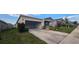Single-story home with gray siding, landscaping, and a two-car garage at 1007 Theodore St, Davenport, FL 33837