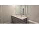 Bathroom boasts double sinks, gray cabinets, and a large mirror at 1007 Theodore St, Davenport, FL 33837