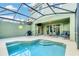 Inviting pool area with covered patio, lounge chairs, and grill at 4738 Terrasonesta Dr, Davenport, FL 33837