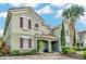 Two-story townhouse with green exterior, red shutters, and a brick walkway at 4738 Terrasonesta Dr, Davenport, FL 33837