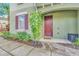 Townhouse entrance with a dark red door and landscaping at 4738 Terrasonesta Dr, Davenport, FL 33837